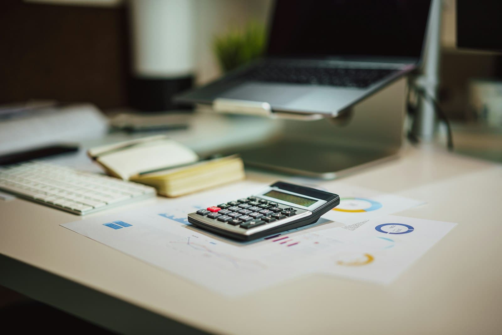 Calculadora ao lado de um notebook sobre uma mesa